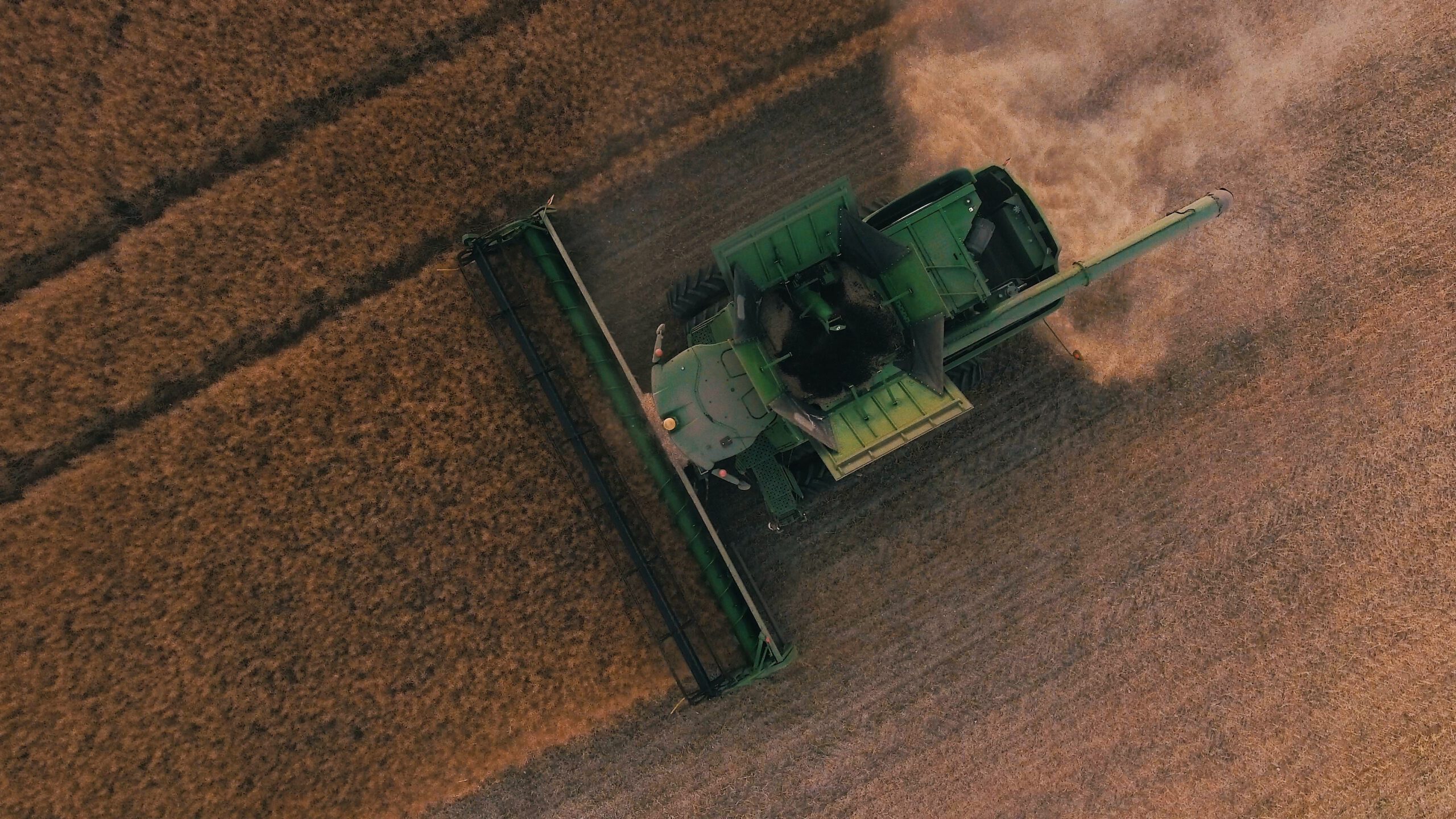 Aerial view of a John Deere combine during a summer wheat harvest. My Grandfather and I used two of these during our own wheat harvest seasons in the late 1990s / early 2000s. It was my first "job". Photo by Scott Goodwill on Unsplash